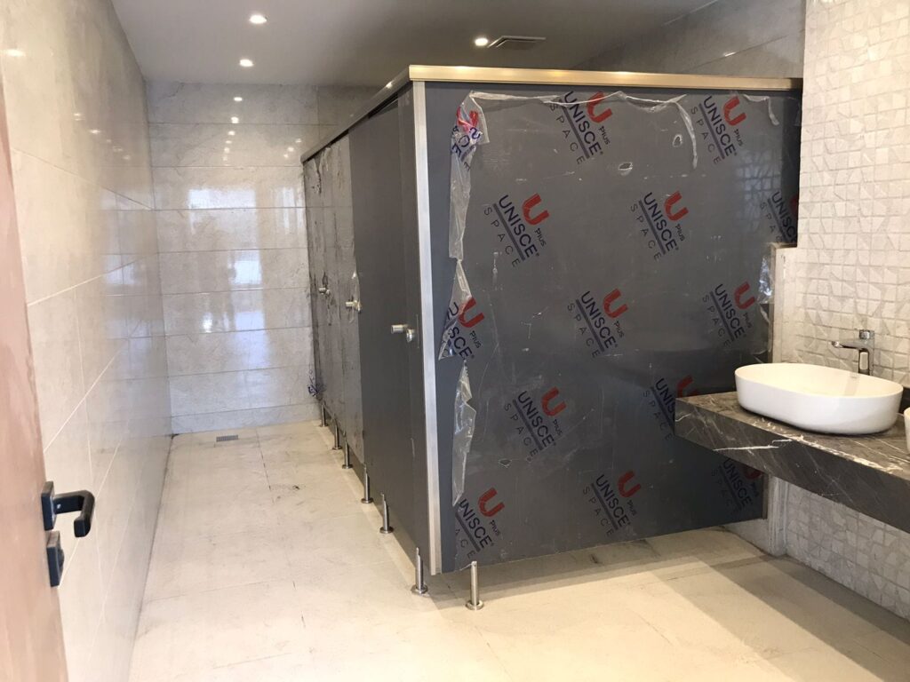 تركيب قواطيع حمامات كومباكت داخل دورة مياه حديثة، يظهر تقسيم الكبائن بجودة عالية مع خامات متينة وتشطيب نظيف مناسب للمشاريع التجارية في القاهرة
