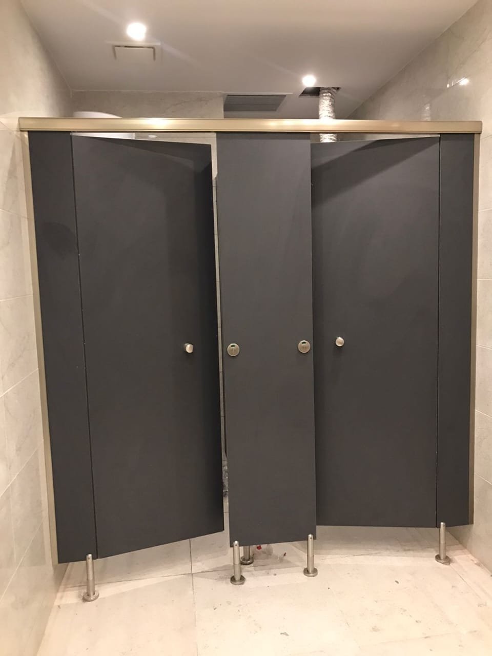 Compact HPL cubicle doors and pilasters in a Badr City washroom