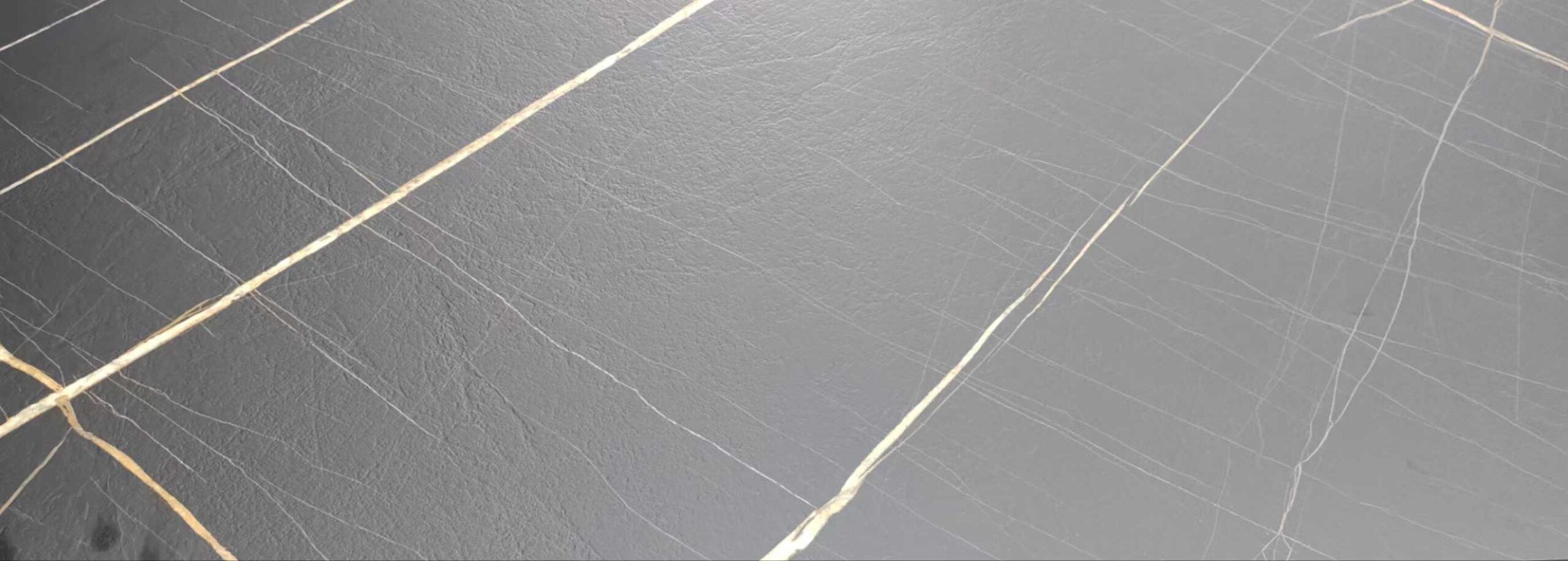 Grey marble-look JAICAN Corian solid surface swatch from Cairo House, with warm cream tones, soft grey clouding and rust veining, a colour chosen for Corian table tops in Cairo hotels and cafes that want a natural stone look without natural stone.