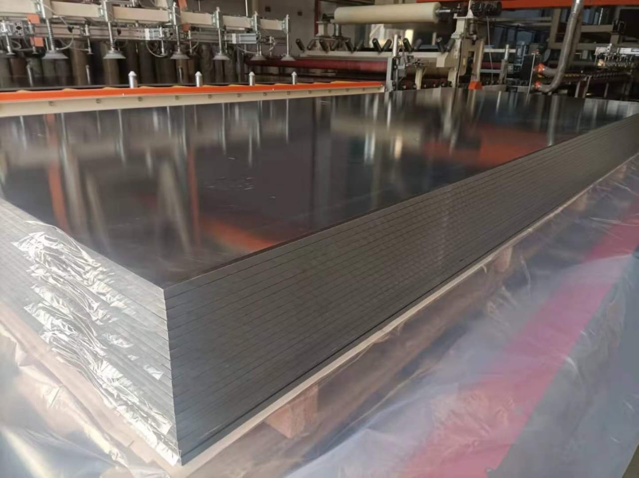 Dark grey solid surface panel sheets stacked on the production line at the factory supplying Cairo House, the exposed edges showing consistent thickness and a dense core used for Countertops in Cairo commercial projects.