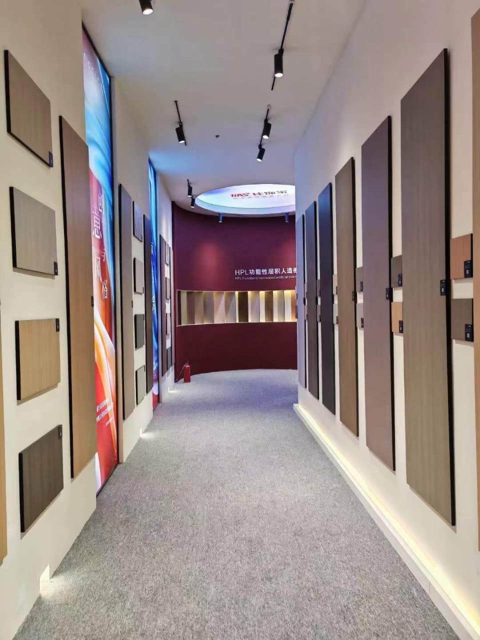 Corridor of compact HPL sample panels mounted on both walls, showing wood, stone and solid colour finishes. Cairo House supplies and installs Compact HPL in Cairo for offices, clinics, hotels and residential fit out projects across the city.