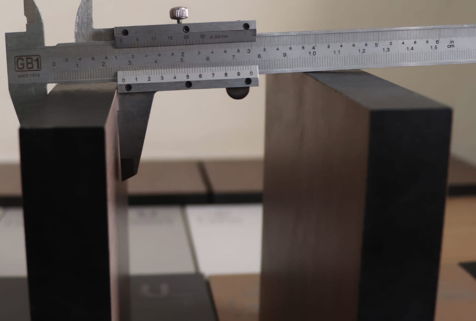 Vernier caliper measuring the thickness of a compact HPL panel at Cairo House in New Nozha, Cairo. Checking board thickness confirms the Compact HPL in Cairo grade suits partitions, cubicles and worktops before supply to site.