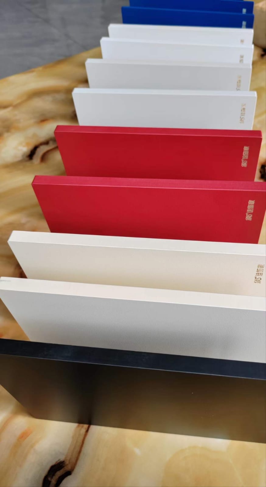 Row of thick compact HPL panels in blue, white, red and grey standing on edge at Cairo House in New Nozha, Cairo. These self supporting boards show why Compact HPL in Cairo suits worktops, cubicles and heavy duty surfaces on site.