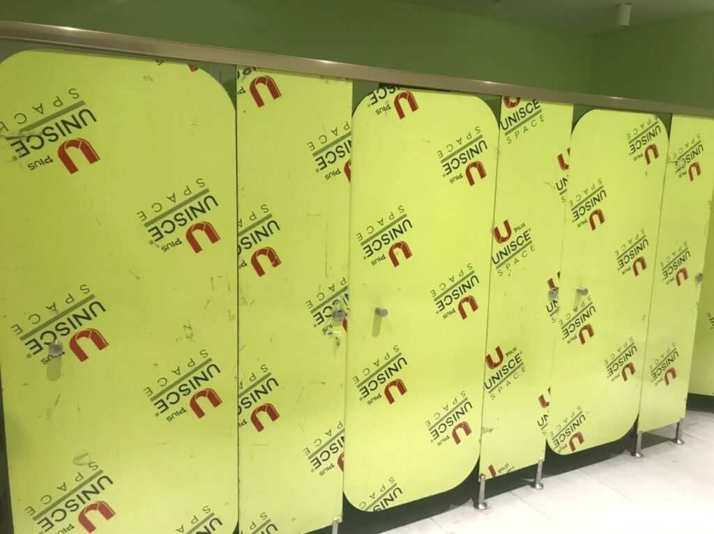 Lime green UNISCE panels for compact HPL partitions in Cairo seen up close before the film is stripped. Cairo House holds colour stock in Egypt so compact HPL bathroom partition orders in Cairo do not wait on shipping.
