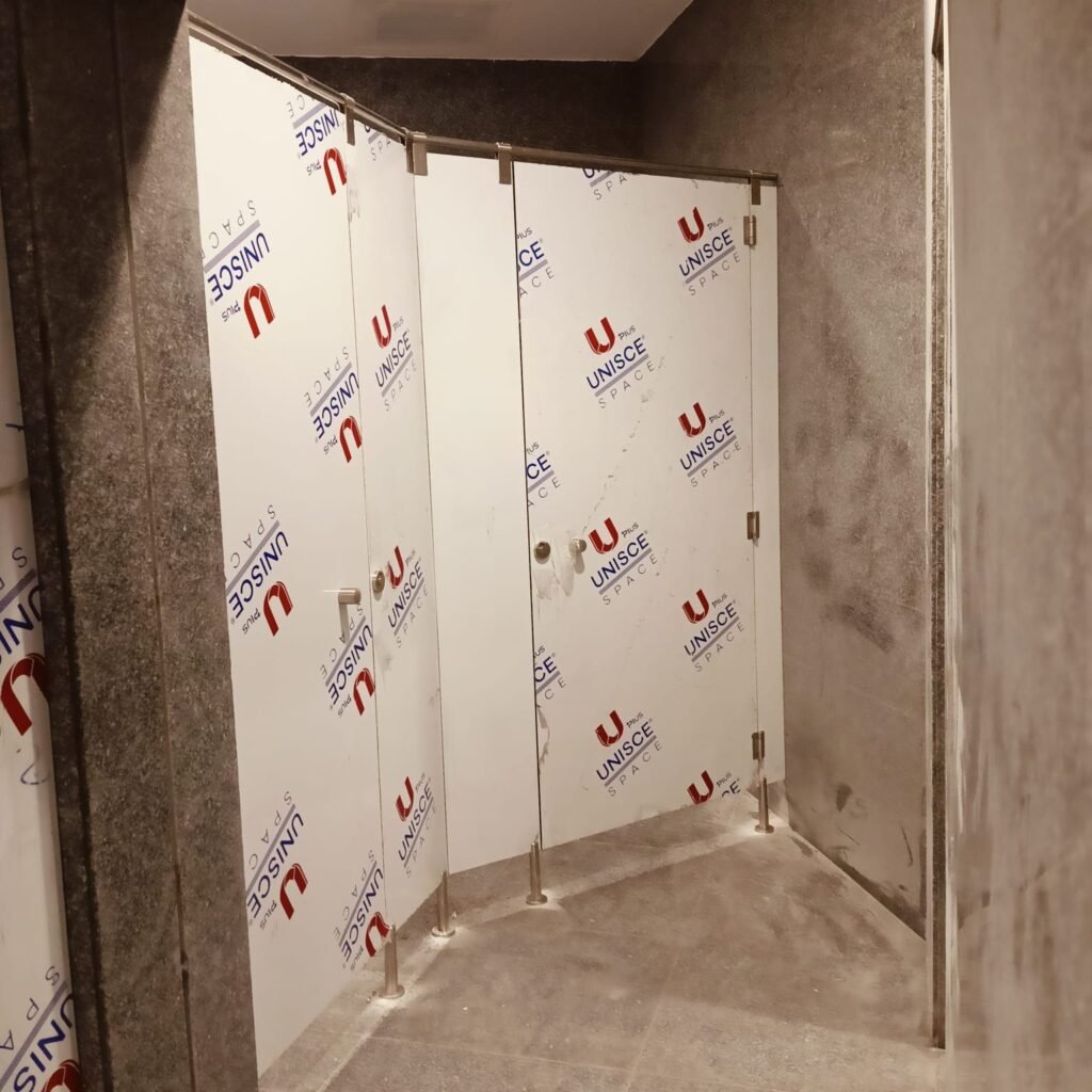 A filmed UNISCE panel for compact HPL partitions in Cairo set against a marble wall. Cairo House scribes compact HPL bathroom partitions to out of square walls rather than leaving a gap on Cairo projects.