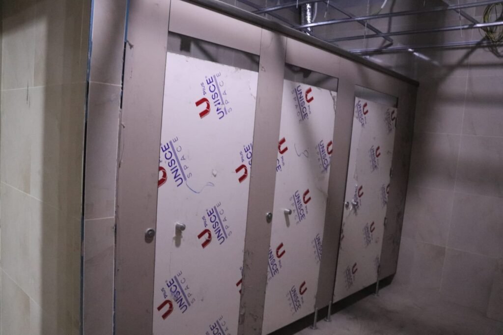 UNISCE panels for compact HPL partitions in Cairo stacked on site before assembly. Cairo House cuts and edges every compact HPL bathroom partition to the washroom survey so nothing is trimmed on site in Cairo.