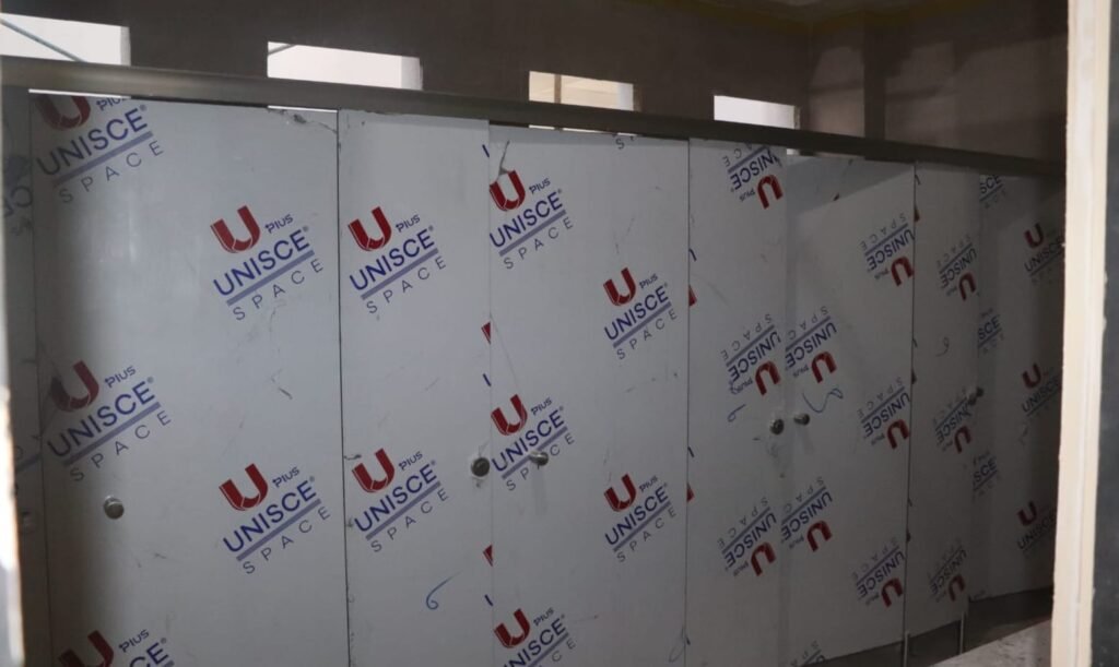 A sand coloured run of compact HPL partitions in Cairo, filmed and standing before final clean. Cairo House installs compact HPL bathroom partitions for malls, hospitals and office towers right across Cairo.