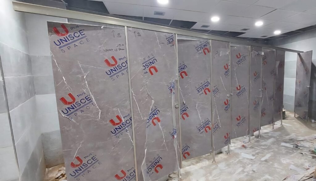Stone look compact HPL partitions in Cairo lining a commercial washroom. The marble effect decor gives compact HPL bathroom partitions in Cairo the look of stone with none of the weight or the sealing.