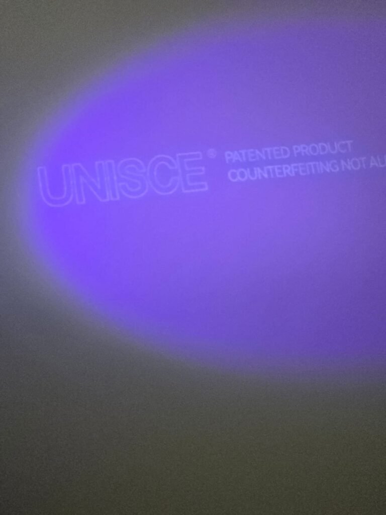 The UNISCE anti counterfeiting mark glowing under UV on stock for compact HPL partitions in Cairo. Counterfeit board is common in the market, so Cairo House verifies every compact HPL bathroom partition panel it imports.