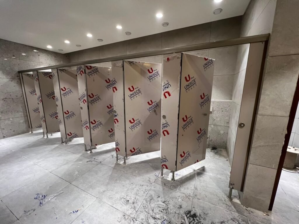 Wide view of compact HPL partitions in Cairo in a marble lined washroom. Cairo House supplies UNISCE compact HPL bathroom partitions with matching pilasters, headrails and stainless fixings for Cairo commercial projects.